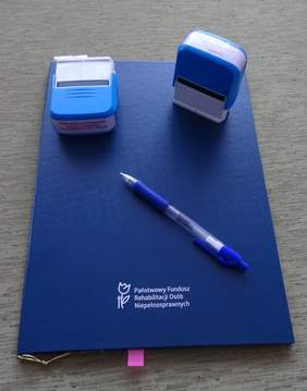Teczka PFRON i pieczątki - jako symbol podpisania Porozumienia