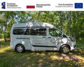 Pokaż zdjęcie: Na górze, od lewej strony widoczne są następujące logotypy: Funduszy Europejskich – Programu Wiedza-Edukacja-Rozwój; Rzeczpospolitej Polskiej oraz Unii Europejskiej – Europejskiego Funduszu Społecznego. Poniżej na polanie, w pobliżu zagajnika brzozowego stoi biały bus z logotypem Gminy Września oraz naklejką informującą o dofinansowaniu zakupu pojazdu w ramach konkursu grantowego PFRON pn. „Usługi indywidualnego transportu door-to-door oraz poprawa dostępności architektonicznej wielorodzinnych budynków mieszkalnych”.