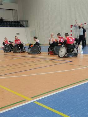 zdjęcia z rozgrywek, 6 zawodników na wózkach inwalidzkich na sali oraz sędzia