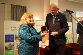 Prezes Fundacji - Pani Janina Mirończuk odbiera medal od Prezydenta Torunia