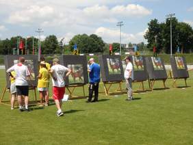 Pokaż zdjęcie: Na tarczach do strzelani umieszczony jest kozioł. Sędziowie sprawdzają wyniki.