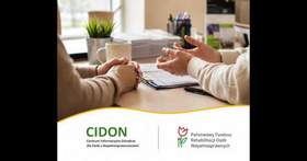 Na biurku leżą dłonie dwóch rozmawiających ze sobą osób. W tle widać różne dokumenty, długopisy, kubek i kwiat. Na dole znajduje się logo PFRON i CIDON. 
