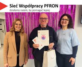 Na górze, na białym tle, widoczny jest czerwony, trójkątny element. Obok znajduje się tekst: 'Sieć Współpracy PFRON', a poniżej napis: 'działamy razem, by pomagać lepiej'. W centrum stoi mężczyzna trzymający dyplom oraz białą torbę z logo PFRON. Po lewej towarzyszy mu kobieta o długich blond włosach w okularach. Po prawej stoi kobieta z ciemnymi, kręconymi włosami w okularach, ubrana w jasnoniebieski sweter.