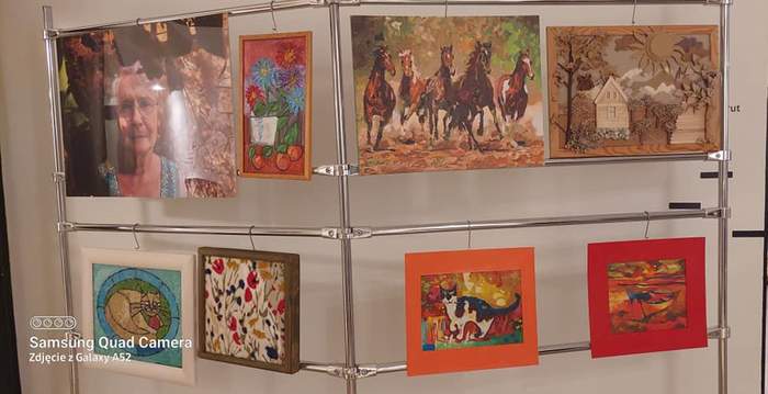 Pokaż zdjęcie: Zdjęcia 8  prac plastycznych zawieszone  na metalowych stojakach  