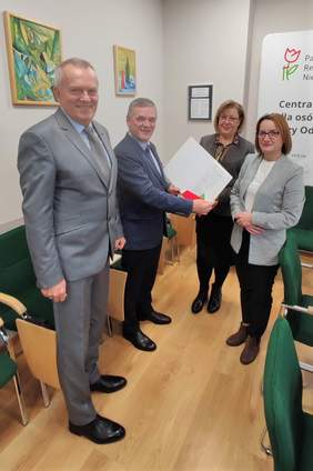 Pokaż zdjęcie: Dwóch mężczyzn i dwie kobiety. W rękach trzymają  dokumenty.