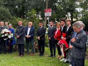 Grupa osób z wiązankami kolorowych kwiatów