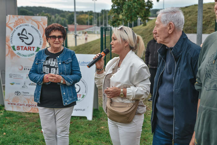 Pokaż zdjęcie: Na pierwszym planie Dyrektorka Oddziału PFRON, która trzyma w ręku mikrofon, a obok niej pozostali uczestnicy spotkania