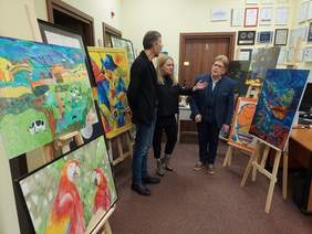 Pokaż zdjęcie: na zdjęciu pomiesczenie Oddziału Łódzkiego PFRON,w którym rozmieszczono nagrodzone prace konkursowe, po środku stoją i rozmawiają członkowie komisji konkursowej 