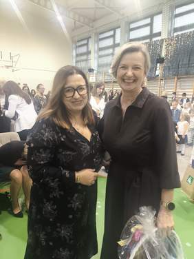 Pokaż zdjęcie: Do zdjęcia pozują dwie uśmiechnięte kobiety, jedna z kobiet trzyma kosz z cukierkami w ręku.