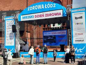 Pokaż zdjęcie: Na scenie występuje artysta z niepełnosprawnością. Przed sceną stoją ludzie, którzy oglądają występ. 