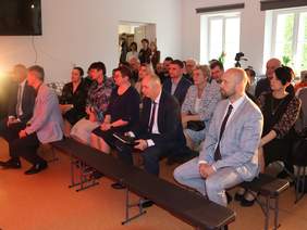 Pokaż zdjęcie: Zaproszeni goście siedzą na przygotowanych krzesłach. 