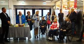 Zwiedzający wystawę słuchają przemóienia przedstawicielki Oddziału Regionalnego Olimpiad Specjalnych