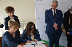 Pokaż zdjęcie: Osoba składa podpis pod umową