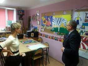 Pokaż zdjęcie: Terapeuta z WTZ w Kazimierzy Wielkiej prezentuje Dyrektorowi Oddziału Świętokrzyskiego PFRON Andrzejowi Michalskiemu twórczość Waldemara Pudo 