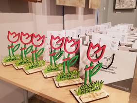 Statuetki - drewniane tulipany logo pfron oraz torebki z logo pfron z nagrodami na laureatów