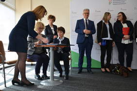 Pokaż zdjęcie: Dwie osoby składają podpis pod umową