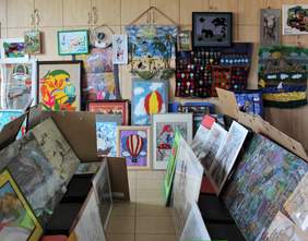 Pokaż zdjęcie: Prace plastyczne zgłoszone w kategoriach: rysunek i grafika oraz tkanina i aplikacja rozwieszone na ścianie