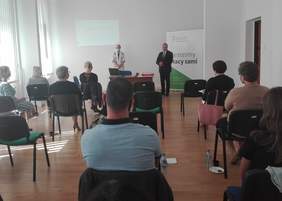 Pokaż zdjęcie: W centralnej części zdjęcia witający uczestników spotkania Dyrektor Oddziału Śląskiego PFRON - Jan Wroński i stojąca obok prowadząca spotkanie - Teresa Saczuk Ekspert do spraw współpracy z Administracją Publiczną, tyłem uczestnicy spotkani