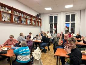 Uczestnicy spotkania siedzą przy stolikach na sali w PZG.