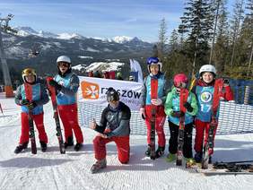 6 osób, narciarze pozują do zdjęcia, słoneczny dzień, zimowa aura, w tle góry