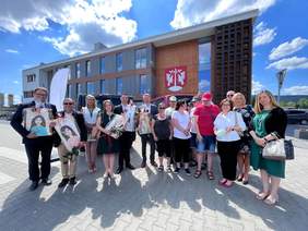 Pokaż zdjęcie: Uroczystość przekazania mikrobusu dofinansowany ze środków PFRON, zakupiony na rzecz WTZ w Harbutowicach. Grupa uczestników uroczystości przed budynkiem Starostwa Powiatowego w Myślenicach