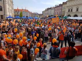 Tłumy ludzi z pomarańczowymi balonami i elementami ubrań w tym kolorze zebrani na jarosławskim rynku