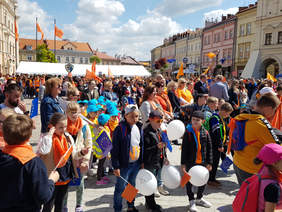 tłumy na jarosławskim rynku, słoneczny dzień, pomarańczowe elementy, flagi, balony
