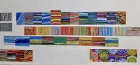 Pokaż zdjęcie: na białej ścianie zawieszone cztery rzędy barwnych obrazów