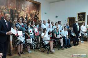 Pokaż zdjęcie: Na tle obrazu w muzeum pozują do pamiątkowego zdjęcia uczestnicy gali.