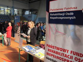 Pokaż zdjęcie: Pracownik_Oddzia_u__wi_tokrzyskiego_PFRON_Pani_Bo_ena_Obara_na_stoisku_Oddzia_u.JPG