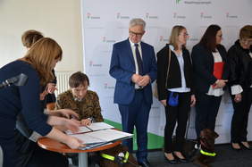 Pokaż zdjęcie: Osoba składa podpis pod umową