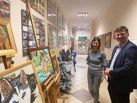 Pokaż zdjęcie: Galeria prac jest wystawiona na korytarzu budynku. Widać tu obrazy stworzone różnymi technikami. Techniką naklejania papierowych pasków zrobiony jest obraz psa haski. Olejną farbą namalowana jest Matka Boska. Z łączenia różnych materiałów pow