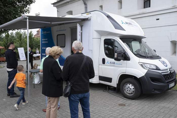 Pokaż zdjęcie: Biały bus na tle budynku