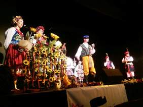 Pokaż zdjęcie: Grupa śpiewających artystów w strojach ludowych