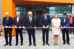 Pokaż zdjęcie: Oficjalne przecięcie wstęgi przed budynkiem Centrum Pomocy Osobom z Autyzmem