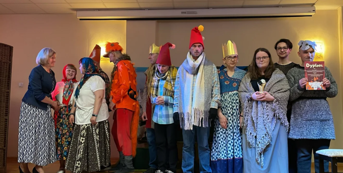 Pokaż zdjęcie: Na scenie dyplom i statuetkę odbiera jedna z grup teatralnych, przebrana za krasnoludki. 