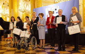 Pokaż zdjęcie: Dziesięć osób na środku sali zamku królewskiego pozuje do zdjęcia