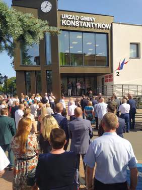 Pokaż zdjęcie: Przed nowym budynkiem gminy, stoją zaproszeni goście. 