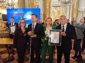 Pokaż zdjęcie: Do pamiątkowego zdjęcia pozują dwie kobiety oraz dwóch mężczyzn. Jeden z mężczyzn trzyma w ręku laskę dla niewidomych, drugi mężczyzna trzyma dyplom.