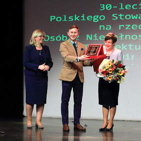 Pokaż zdjęcie: Przewodnicząca Koła odbiera statuetkę z rąk przedstawicieli PFRON