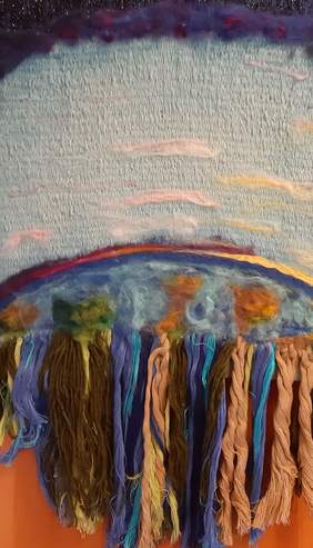 Pokaż zdjęcie: Na środku słońce w intensywnej czerwieni na tle jasno pomarańczowego i beżowego z domieszką brudnego błękitnego nieba. Poniżej w barwie ciemniejszego błękitu woda, na powierzchni z czerwonym, nierównym odbiciem słońca.  