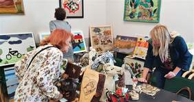 Pokaż zdjęcie: Członkowie Komisji oceniają prace zgłoszone w kategoriach "Rzeźba kameralna i płaskorzeźba" oraz "Tkanina i aplikacja". Oglądają prace wyeksponowane na stole oraz powieszone na ścianie