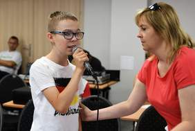 Pokaż zdjęcie: Wykonawca wraz z instruktorem wokalnym podczas warsztatów