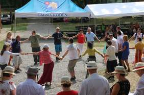 Pokaż zdjęcie: Uczestnicy festiwalu tańczą w kole trzymając się za ręce