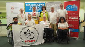 Pokaż zdjęcie: Zawodnicy "Start" Zielona Góra z flagą klubu na tle banerów promocyjnych Mistrzostw