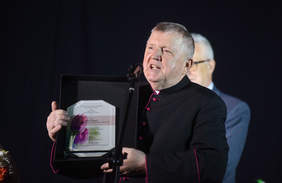 Pokaż zdjęcie: Ksiądz trzyma w ręku uroczysty grawerton