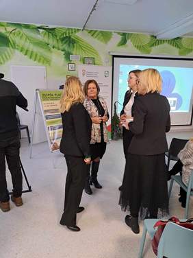 Rozmowy w kuluarach - cztery kobiety stoją na środku sali i rozmawiają