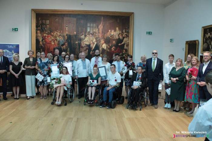 Pokaż zdjęcie: Na tle obrazu w muzeum do zdjęcia zapozowali uczestnicy gali.