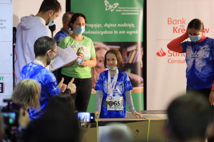 Pokaż zdjęcie: 10-letnia Marlena odbiera nagrodę ufundowaną przez PFRON. Za zajęcie III miejsca w kategorii PTWM dziewczynka otrzymała rower stacjonarny.