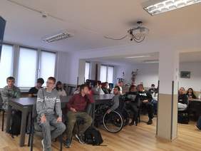 Pokaż zdjęcie: Goście siedzący na krzesłach, w większości uczniowie, młodzież szkolna.